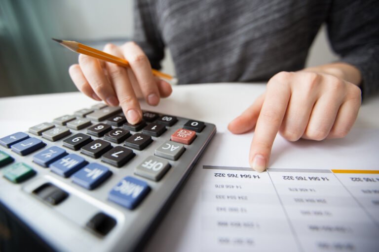 closeup accountant hands counting calculator